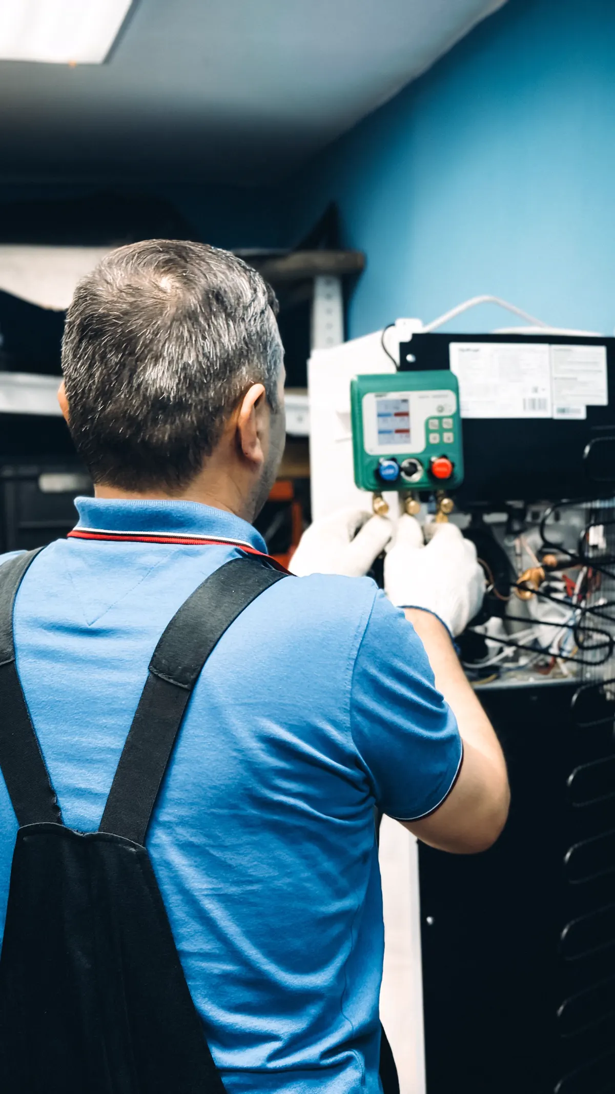 Técnico usando um manifold para medir a pressão de um sistema de refrigeração